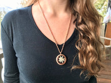 A model wears the 24 inch chain on the Edelweiss circle locket pendant. The locket pendant has a real pressed Edelweiss flower inside. 