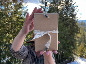 A woman holds up a small herbarium flower press. Handmade by Pressed Wishes.