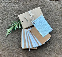 Herbarium Flower Pressing Kit by Pressed Wishes. This image contains the contents of a flower pressing kit including blotting paper, cardboard, wing nuts and an instruction manual. 