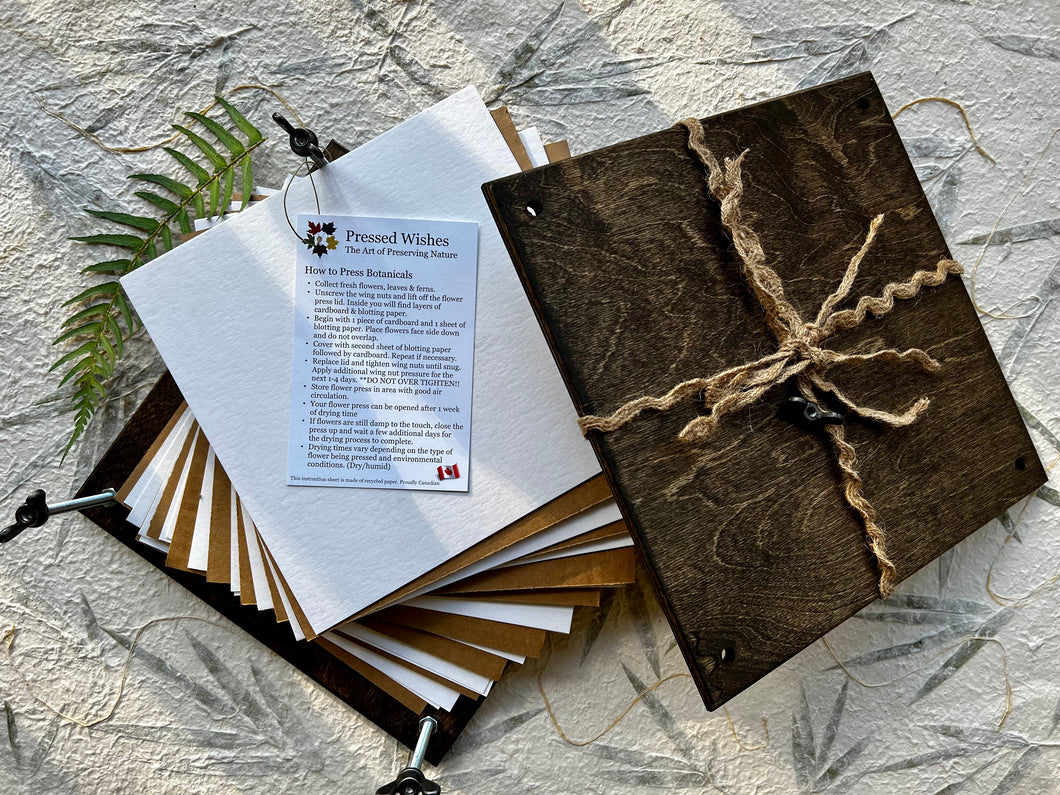 DIY Pressed Flower Kit by Pressed Wishes is displayed. It contains herbarium blotting paper, corrugated cardboard, wingnuts and an instruction book. 