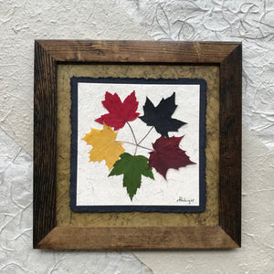 the tattoo; pressed maple leaf artwork with green handmade paper and brown frame